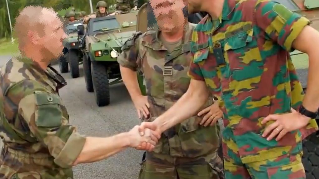 Militaires français et belge en tenue de camouflage se serrant la main